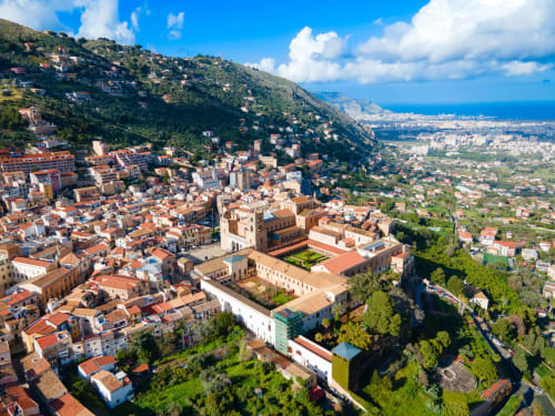 Vista aerea del villaggio San Martino delle Scale immerso nelle colline di Palermo con la costa mediterranea visibile in lontananza