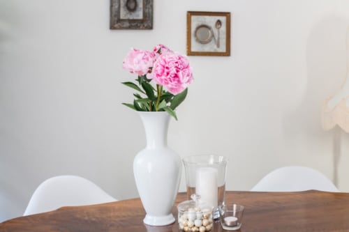 Pink peonies in white vase on wooden table at Alessia's Place B&B in Como, Italy
