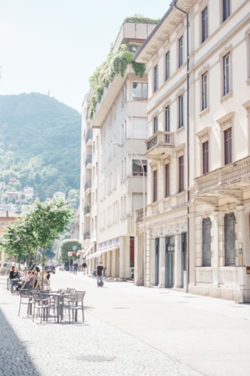 Alessia's Place B&B courtyard in Como, Italy with cream-colored historic buildings and mountain views