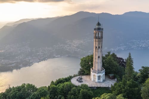 Lighthouse tower overlooking Lake Como with mountains and Italian villages in background near Alessia's Place, Como