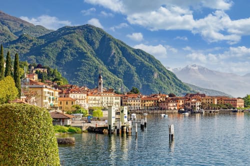 Colorful waterfront buildings of Como, Italy with Alpine mountains, lake, and cypress trees - Alessia's Place B&B location