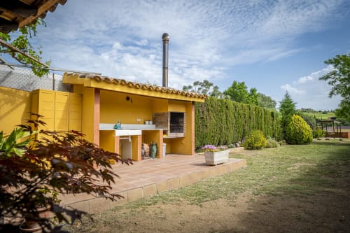 Casa rural amarillo brillante Ca L'Avi en Estada Rural con vistas al jardín, terraza y entorno campestre en España