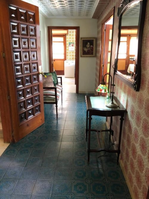 Pasillo de la villa Casa María en Artana con puertas de madera, suelo de azulejos, espejos y vistas a las montañas por las ventanas