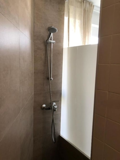 Baño moderno con ducha de efecto lluvia y herrajes cromados en el hotel Casa María de Artana