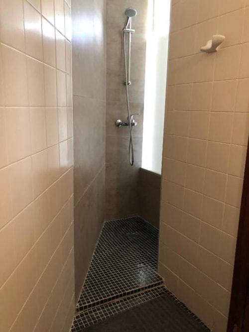 Moderno cuarto de baño con paredes de azulejos y piso de mosaico negro en el hotel Casa María de Artana, España