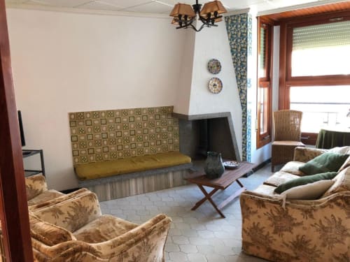 Sala de estar del hotel Casa María en Artana con sofá estampado, sillones y platos decorativos