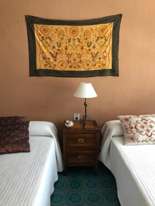 Dormitorio doble en Casa María de Artana con tapiz decorativo, lámpara de mesilla y vistas a la montaña
