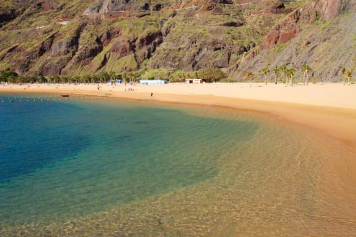 Playa de arena dorada con aguas turquesas cristalinas en Nido Anaga, Santa Cruz de Tenerife, Islas Canarias