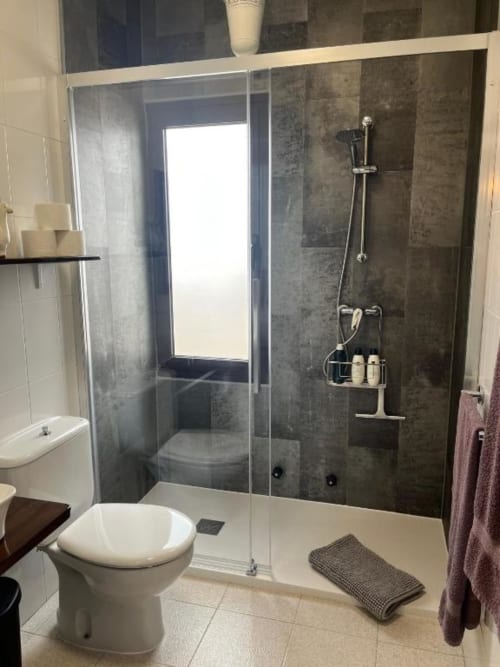 Modern bathroom in Villa Estrella Polar apartment with walk-in shower, toilet, and white vanity in Tahiche