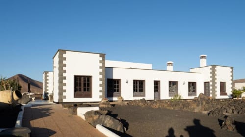 Villa Estrella Polar in Tahiche features white-walled architecture with stone accents and volcanic landscape