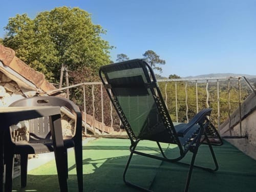 Terrace seating area at Domaine de Cabrières with reclining chair overlooking mountains, St Jean Du Gard