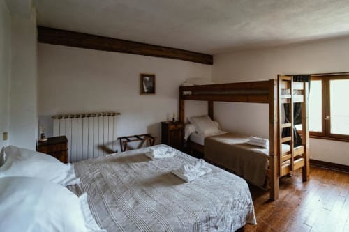 Quadruple bedroom at Domaine de Cabrières B&B with double bed, bunk bed, radiator, and wooden beams in St Jean Du Gard,