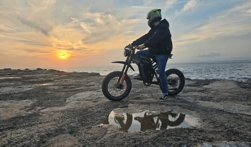 Motociclista de capacete na praia ao pôr do sol, Costa da Caparica, hostel Vila Alexandra