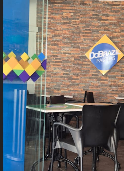 Sala de jantar da pousada DoBrazi Pasteis em Vila Alexandra com placa de diamante colorida e paredes de tijolos