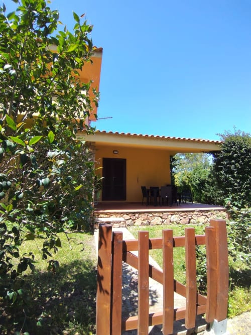 Affascinante villa gialla a San Teodoro con vista giardino, fondamenta in pietra, cancello in legno e vegetazione rigogliosa