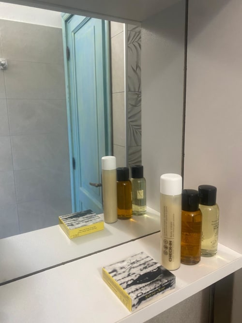 Bathroom vanity at Holidays San Teodoro with toiletries and mirror in villa standard room