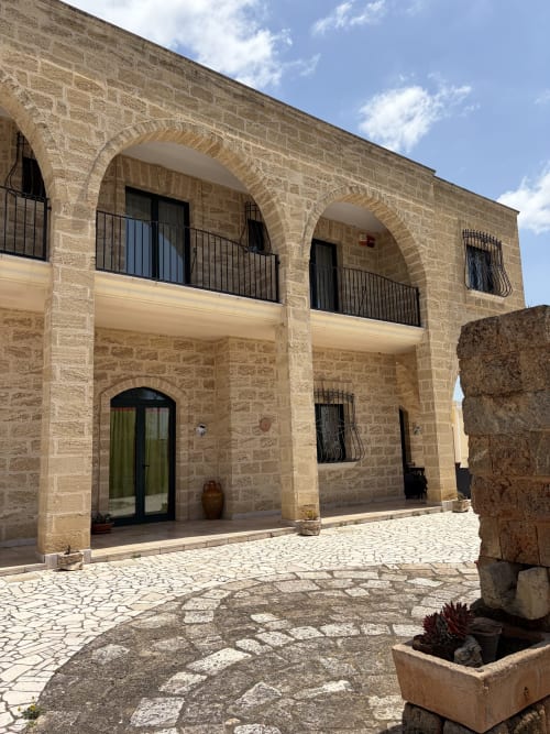 Corte della B&B Villa Arneide a Torre Lapillo con facciata in pietra, balconate arcuate e architettura tradizionale