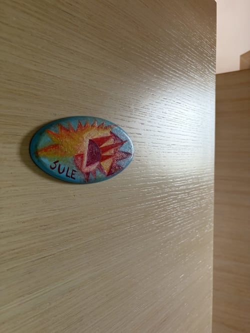 Decorazione ceramica dipinta a mano con sole e conchiglia su parete in legno presso B&B Villa Arneide, Torre Lapillo