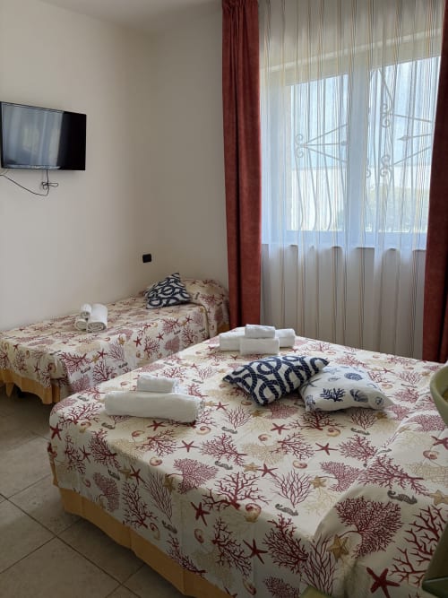 Camera twin del B&B Villa Arneide a Torre Lapillo con biancheria marina, TV a muro e vista sul giardino