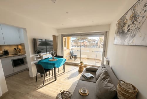 Appartement lumineux à Canet-en-Roussillon avec cuisine ouverte, salle à manger aux couleurs bleues, canapé gris et vue sur la mer