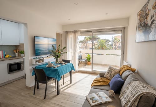 Séjour moderne avec kitchenette, table à manger, canapé et balcon vue mer à Canet-en-Roussillon