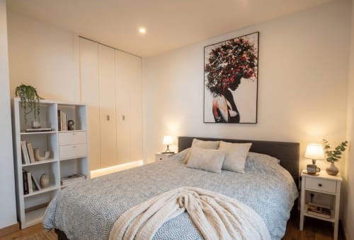 Chambre moderne avec lit queen-size, dressings intégrés et œuvres encadrées à la Conciergerie IB, Canet-en-Roussillon