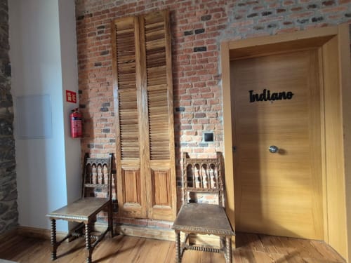 Indiano room entrance at Fabrica de Atardeceres with exposed brick walls, wooden shutters, and period furniture