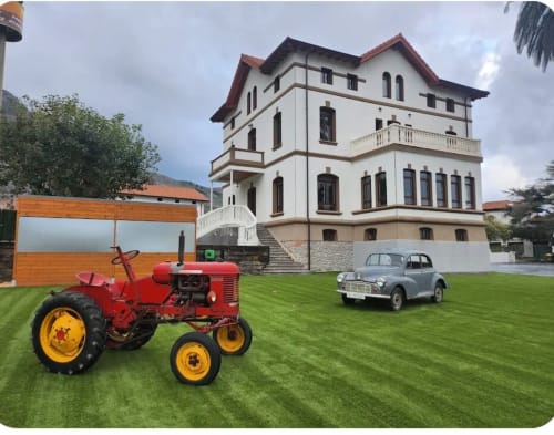 Fabrica de Atardeceres luxury estate with vintage red tractor and classic car on manicured lawn