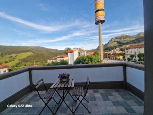 Balcony at Fabrica de Atardeceres with mountain views, table, chairs, and flowering plants in Spain