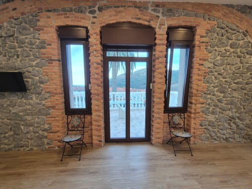 Brick and stone interior with glass doors opening to mountain view at Fabrica de Atardeceres, Spain apartment with seating