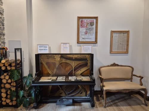 Vintage piano and cream upholstered chair in elegant salon at Fabrica de Atardeceres, Spain