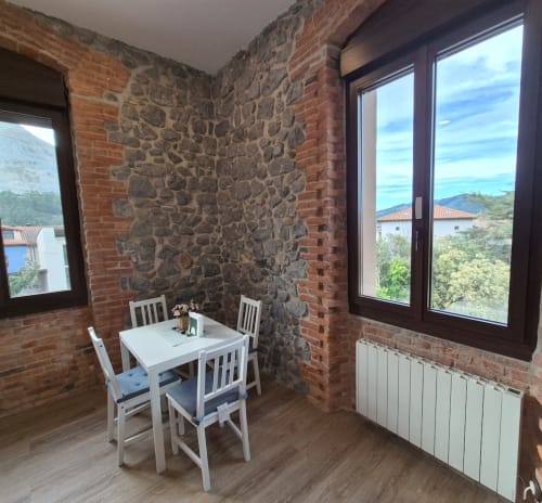 Modern dining area at Fabrica de Atardeceres with exposed brick, stone accents, mountain views, and contemporary furnishings
