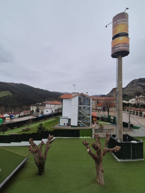 Fabrica de Atardeceres hotel courtyard with grapevines, water tower, and mountain views in Spain