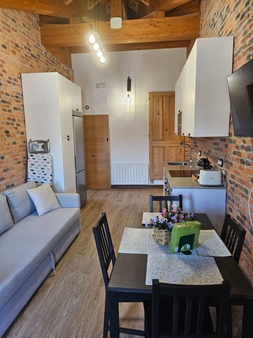 Modern apartment at Fabrica de Atardeceres with open-plan living, dining area, kitchen, exposed brick walls and wooden beams