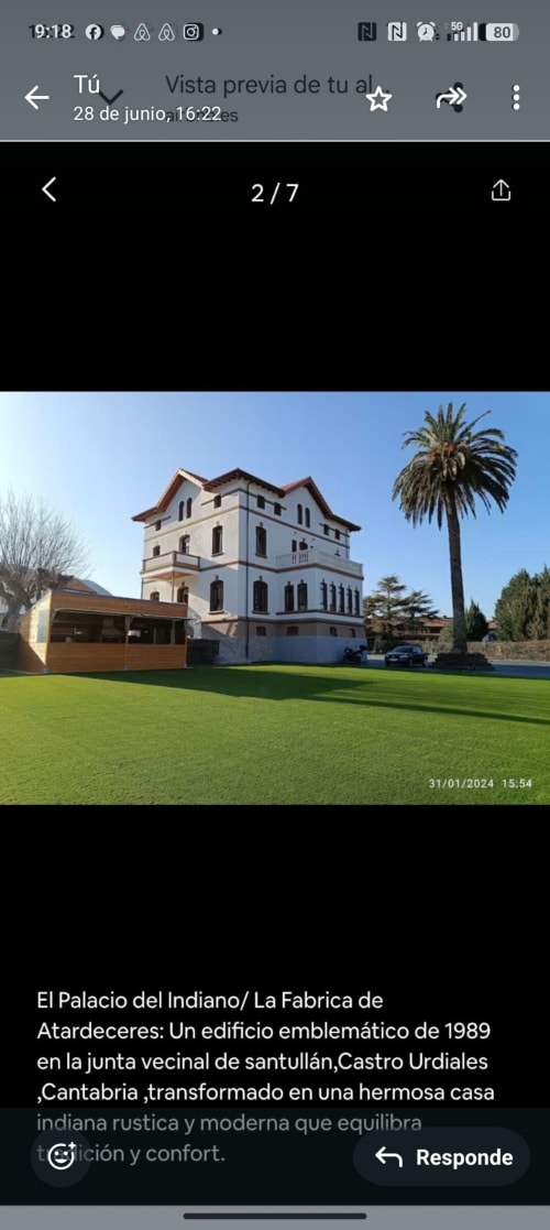 Fabrica de Atardeceres palace exterior with manicured lawn, palm tree, and modern wooden structure in Cantabria