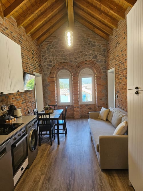 Modern apartment at Fabrica de Atardeceres in Manizales with exposed brick, wooden beams, kitchen, dining area and sofa