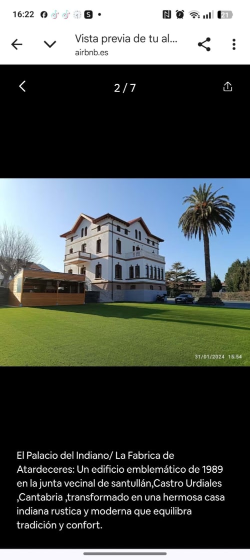 Fabrica de Atardeceres historic palace with manicured lawn, palm tree, and traditional Cantabrian architecture in Castro