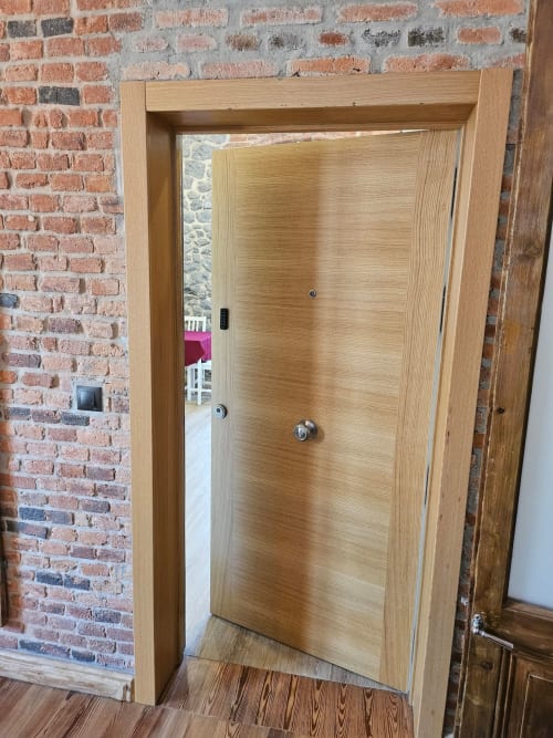 Modern wooden door entrance to Room 4-Barandiaran apartment at Fabrica de Atardeceres hotel in Spain