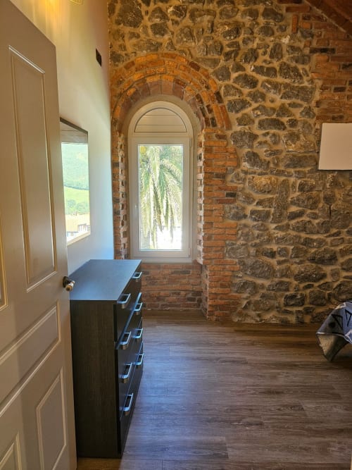 Stone archway entrance with wooden flooring in Room 4-Barandiaran at Fabrica de Atardeceres, Spain