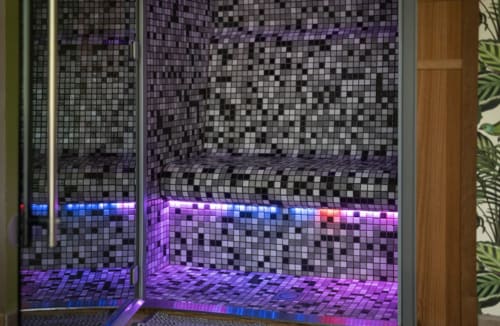 Spa aux carrelages en mosaïque moderne avec éclairage LED violet et bleu à La Cour d'Hortense, hôtel-boutique à Sailly-Flibeaucourt, France