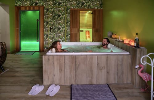 Couple se relaxant dans le bain à remous éclairé de La Cour d'Hortense B&B à Sailly-Flibeaucourt