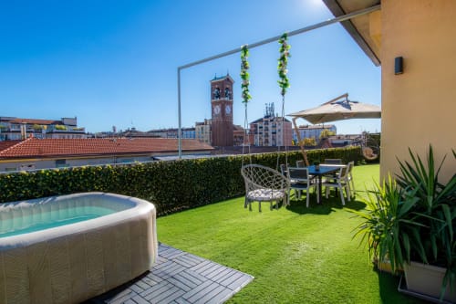 Spacious Milan apartment terrace with private hot tub, lounge seating, and city views of Navigli district