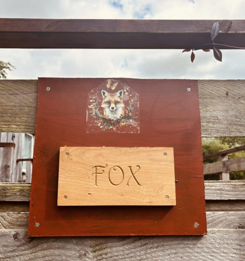 Fox Country Cabin sign at Postwood Gardens Campsite in Kentisbeare with illustrated fox and floral design on wooden entrance