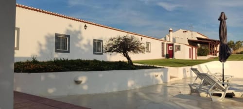 Casa de hóspedes Monte da Morena em Serpa com edifícios caiados, terraço com espreguiçadeiras e vistas para a zona rural