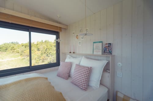 Chambre lumineuse à la Pépite B&B à Villeneuve avec oreillers à carreaux rouges, lit blanc, poutres bois et vue forêt