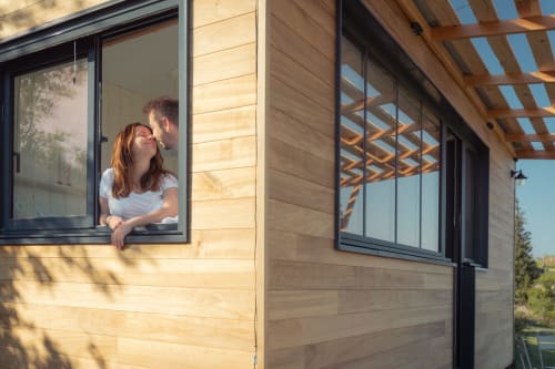 Couple à la fenêtre d'un gîte moderne en bois à Pépiite BnB à Villeneuve, France