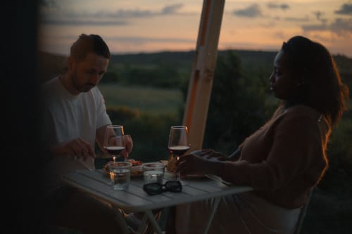 Un couple dînant au coucher de soleil avec vue sur la campagne à la Pépite bnb à Villeneuve, France