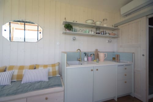 Cozy studio room at Pépiite BnB with bed, kitchenette sink, shelving, and blue tile backsplash in Villeneuve