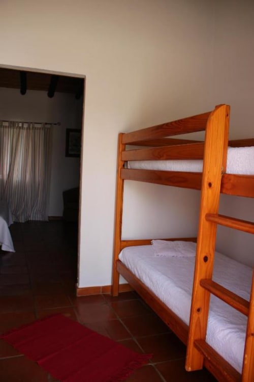 Wooden bunk beds with white linens in a Superior Double Room at Monte Da Morena Agro-Turismo, Serpa, with terracotta flooring
