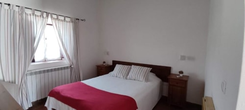 Bright Standard Double Room at Monte Da Morena in Serpa with dark wood bed, white bedding, red blanket, and garden view from